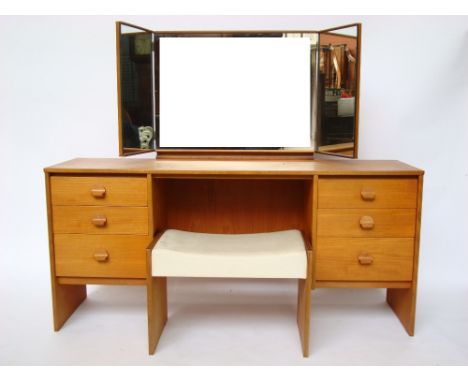 A Stag teak dressing table, with triple aspect mirror and matching stool (2). 