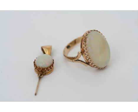 An opal ring, the oval cabochon stone, claw set on unmarked shank size K 1/2, together with yellow metal mounted opal pendant