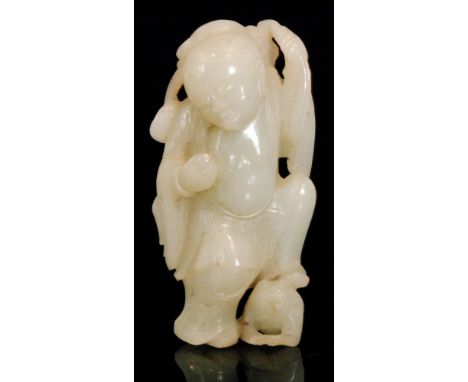 A late 19th and early 20th Century Chinese republic period carved jade figure of a monk with left foot resting on a toad, hei