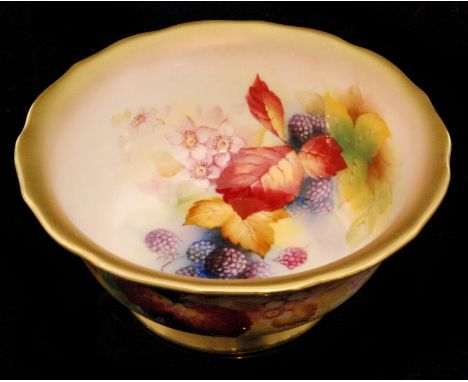 A Royal Worcester footed bowl decorated by Kitty Blake with hand painted autumnal fruits and foliage against a pale ground, s