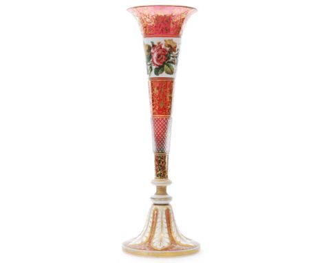 A large 19th Century Bohemian glass vase of footed trumpet form, cased in opal over clear over ruby, cut with leaf form panel