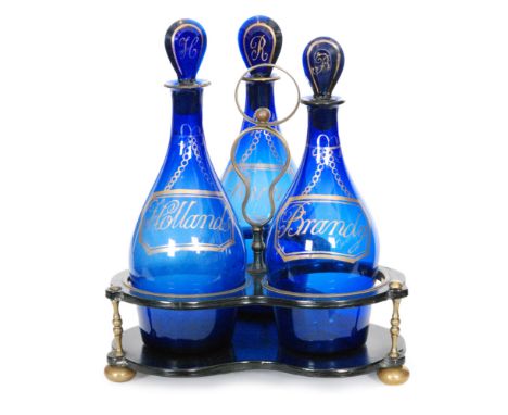 A late Georgian three bottle decanter stand circa 1820, the papier mache stand with brass feet, supports and handle, mounted 