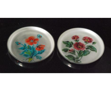 A pair of Danish sterling silver circular pin dishes each with enamel floral spray decoration to a pale grey ground, diameter