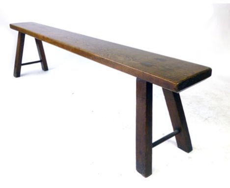 A 19th century elm pig bench with exposed tenons and fox wedges, on four splayed legs with two plain strechers, h. 50 cm, l. 
