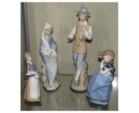 Lladro figure holding lilies, a Lladro figure carrying a piglet, Nao figure of a girl with puppy and one other Spanish porcel