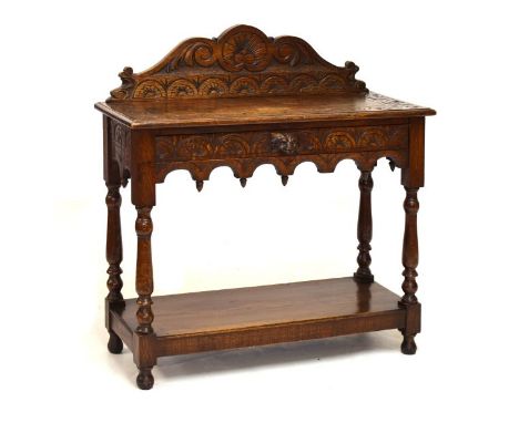 Early 20th Century oak side table having carved back and mask head handle to the single drawer with shelf below, 91cm wide  