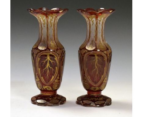 Pair of Bohemian ruby cased glass baluster shaped vases with gilt decoration, 21.5cm high  