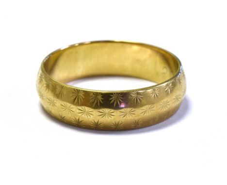 9CT GOLD ENGRAVED WEDDING BAND 5.5mm wide decorated with star burst engraving, ring size P.  Hallmarked 9.375 London 1972.  W
