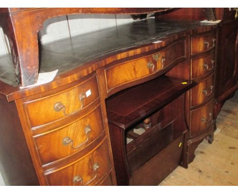 Reproduction mahogany serpentine fronted desk having green leather inset, top above an arrangement of nine drawers with brass