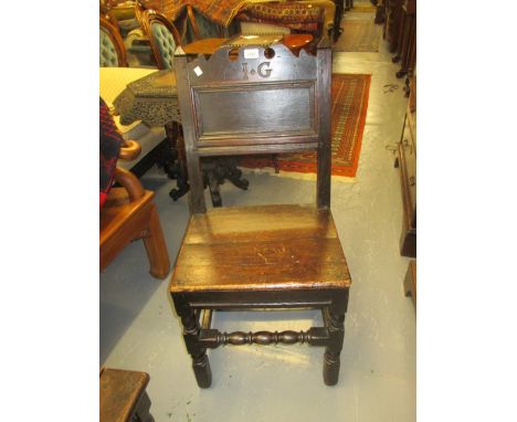 17th Century oak side chair, the rectangular panelled back with shaped surmount carved with the initials I.G., the plank seat