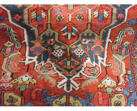 Small Heriz carpet with a typical lobed medallion design on a brick red field with borders, 9ft x 5ft 6ins approximately