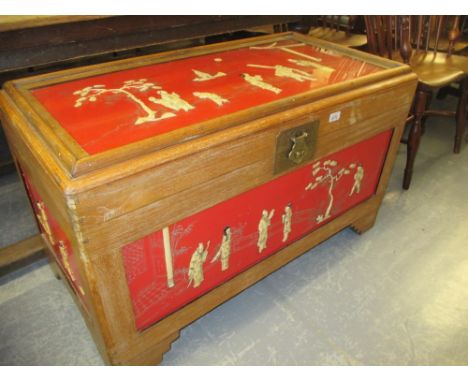 Chinese camphor wood and red lacquer trunk decorated with figures in relief 