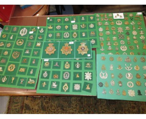 Collection of military helmet plates, cap badges and other badges mounted on six cards