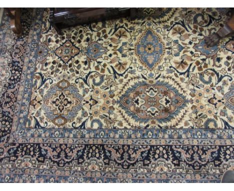 Large Indo Persian woollen carpet with all-over floral design with multiple borders on a beige ground, approximately 11ft x 8