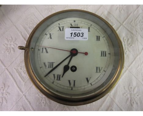 Early 20th Century ships brass cased bulk head clock with a single train key wind movement, the enamel dial with Roman numera