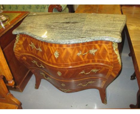 Early 20th Century Continental bombe commode, the marble top above three parquetry decorated drawers with gilt brass floral h