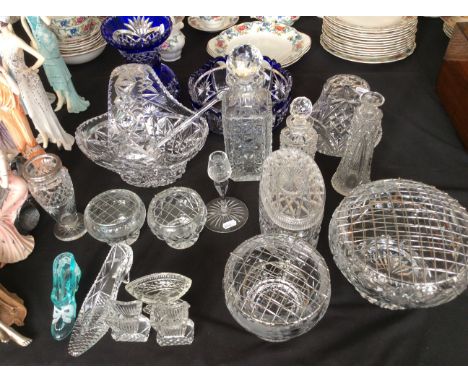 A collection of cut glass including a rose bowls, vase, decanters, candlestick holder, blue case and bowl, etc.