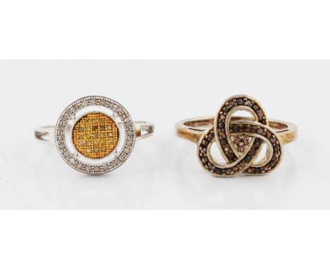 Two diamond rings, one of halo design set with yellow and colourless diamonds, the other of Celtic design set with orange dia