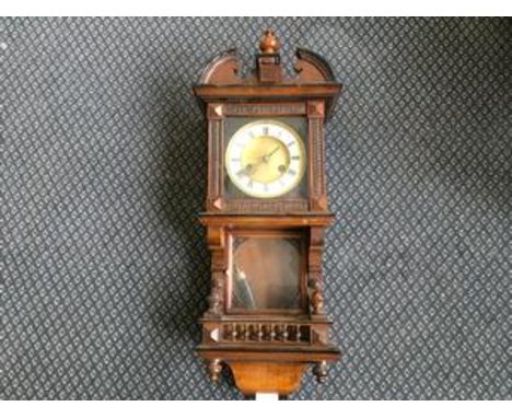 A small mahogany wall clock with gallery shelf