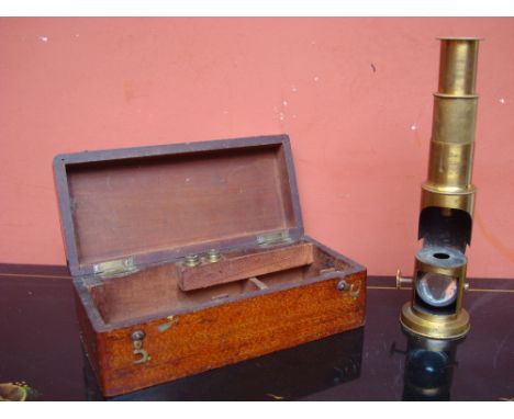 A brass field microscope, with mirror, in original case with two spare lenses. 