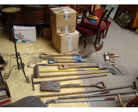 A collection of gardening tools to include spades, rakes, trowels etc, together with a flower stand.