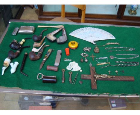A mixed lot comprising of smoking pipes, tobacco knife, a lighter etc, along with various religious pendants and trinkets.