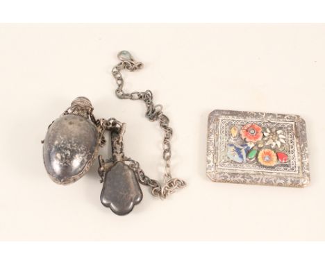 A white metal scent bottle on suspension plus a compact