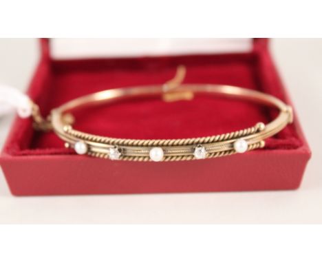 A gold bangle set with pearls and diamonds (marks rubbed)