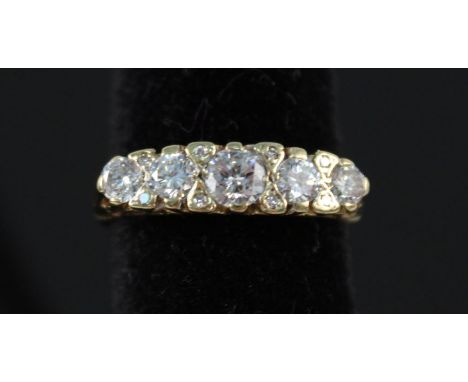 A Victorian style 18ct gold five stone diamond ring interspersed with smaller diamonds in fancy scroll work setting, size L