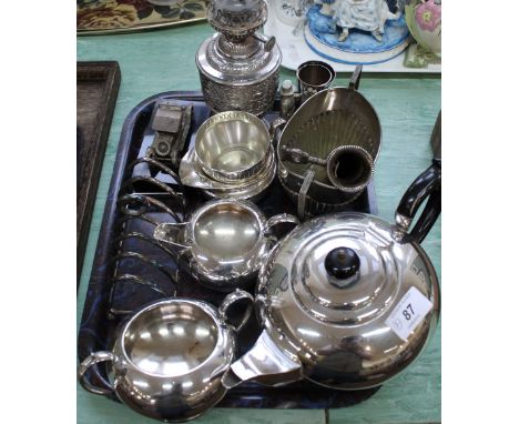 A small ornate silver plated oil lamp, three piece tea set, ham holder plus other items including a papier mache snuff box