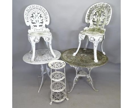 A painted cast metal circular garden table, 80cm x 69cm, another, 69cm x 65cm, two matching chairs and a four tier plant stan