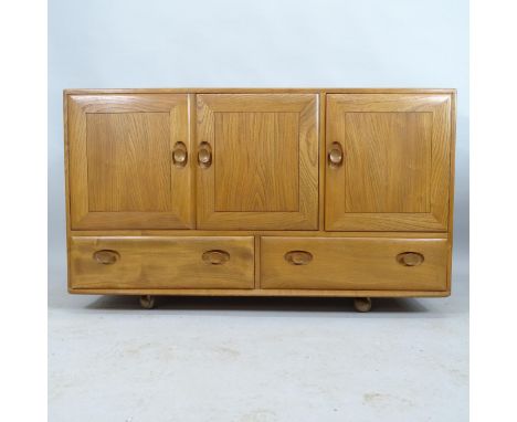 A mid-century Ercol Windsor sideboard with three cupboard doors and drawers under. 130x76x46cm 