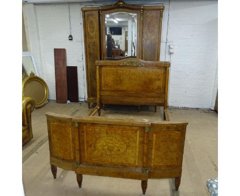 An antique French bedroom suite comprising a crossbanded walnut and satinwood strung three-door armoire with inlaid floral de