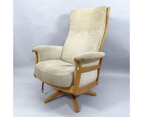 A mid-century Ercol Gina swivel reclining lounge chair, with ash frame, upholstered cushions and maker's label. 