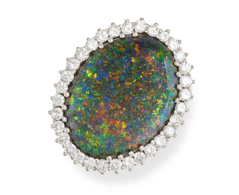 A BOULDER OPAL AND DIAMOND CLUSTER RING in white gold, set with an oval cabochon cut boulder opal in a cluster of round brill