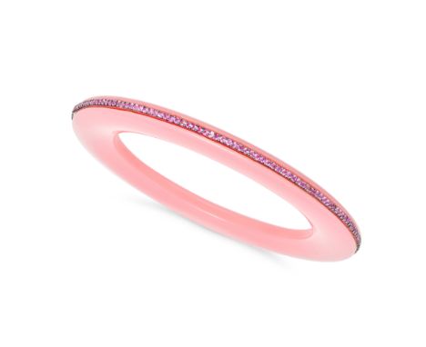 A PINK SAPPHIRE BANGLE comprising a pink plastic bangle accented by a row of round cut pink sapphires, no assay marks, inner 
