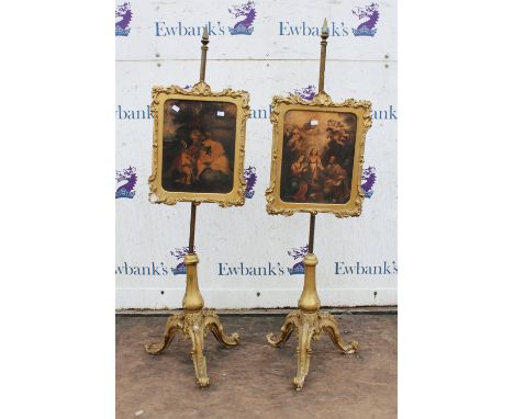 A pair of Victorian giltwood and gesso firescreens, the brass poles with framed glazed panels of religious scenes, on tripod 