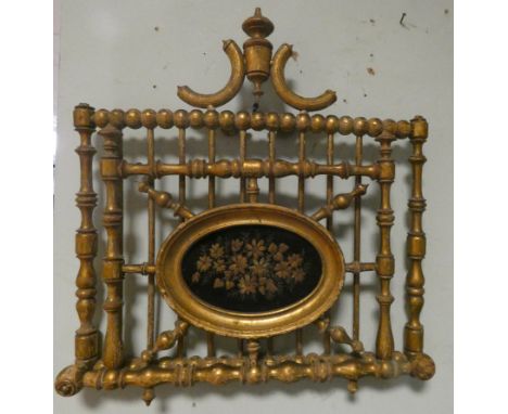 An early Victorian decorative gilt wood bobbin and spindle framed magazine rack with oval tapestry panel  
