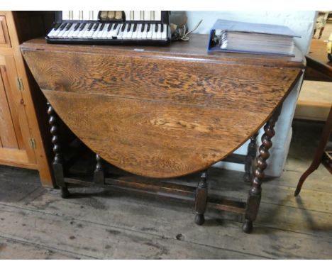 An oval oak gate leg dining table on barley twist legs 3'6 wide 