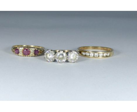 Large three stone dress ring on a 9ct gold shank, ruby three stone ring on 9ct gold shank and another 9ct gold ring