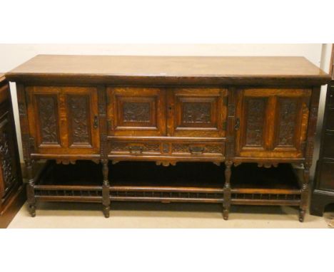 An Early 19th century carved oak Arts and Crafts style sideboard with floral decorated floral door and shelf under, 6' wide 