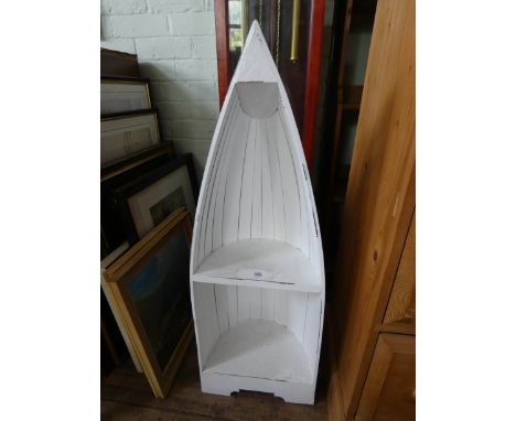 A small white painted boat shaped display shelf or bookshelf 