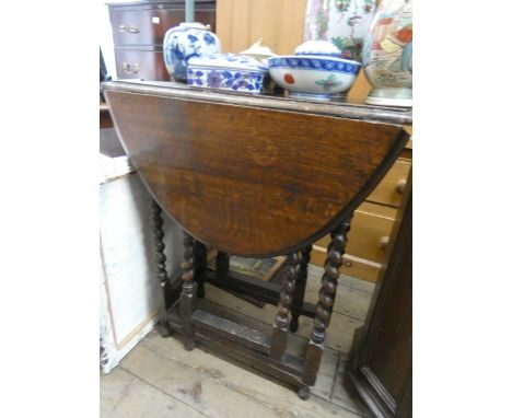 An oval oak gate leg table on barley twist legs 2' wide 