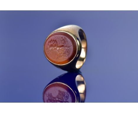 An 18ct gold signet ring set with a 19thC intaglio seal depicting a chariot and charioteer, 15.6g, size O