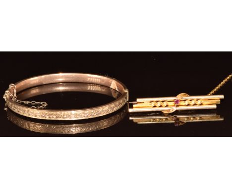 A 9ct rose gold bangle with ivy decoration (5.7g) and a 15ct gold brooch set with a ruby (4.7g)