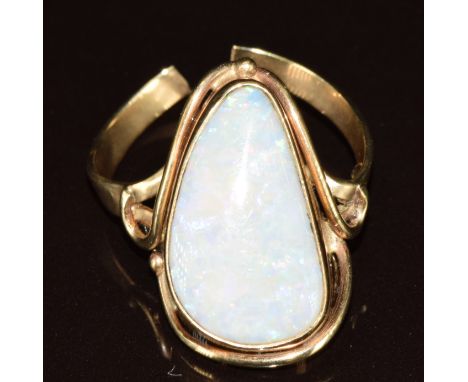 A 9ct gold ring set with a white opal cabochon (band cut), 5.6g