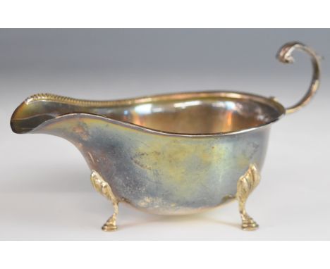 Hallmarked silver sauce boat with beaded edge and scroll handle, raised on three feet, Birmingham 1942, maker Adie Brothers L