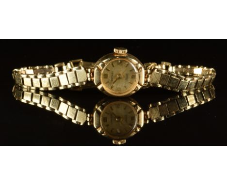 Rotary 9ct gold ladies wristwatch with gold hands and hour markers, champagne dial and mechanical movement, on 9ct gold brace