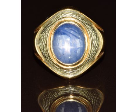 An 18k gold ring set with a star sapphire cabochon with an enamel border, 15.9g, size Q