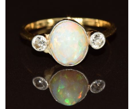 An 18ct gold ring set with an opal cabochon and two diamonds, 2.5g, size N